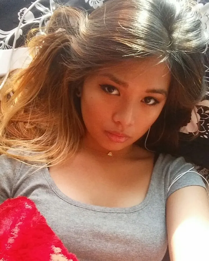 Femme en robe argentée pailletée, prenant un selfie devant un grand miroir doré